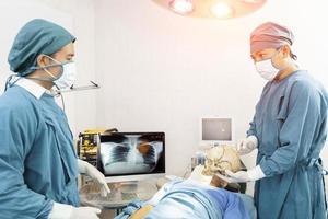 cirujano y asistente discutiendo juntos en el quirófano. concepto de cirugía y emergencia foto