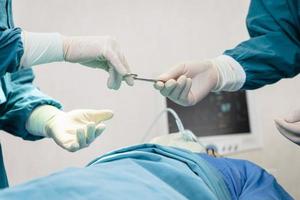 Assistant Hands out Instruments to Surgeons During Operation. Surgery and emergency concept photo