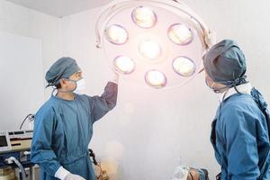 Asistente de cirujano preparando lámparas quirúrgicas en el quirófano