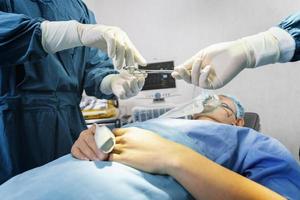 Assistant Hands out Instruments to Surgeons During Operation. Surgery and emergency concept photo