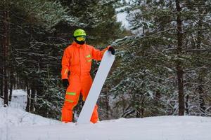 Snowboarder posing in winter forest photo