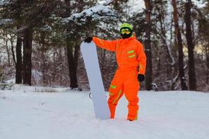 Snowboarder posing in winter forest photo