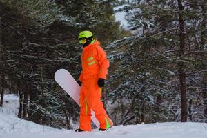 Snowboarder walking through the forest photo