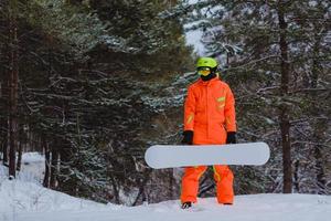 Snowboarder posing in winter forest photo
