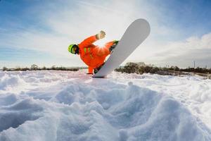 Snowboarder doing a trick on the ski slope photo