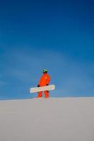 Snowboarder freerider with white snowboard sitting on the top of the ski slope photo