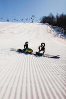 Bottom view on empty ski slope and equipment for snowboarding photo