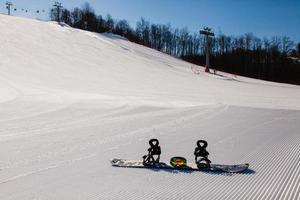 Bottom view on empty ski slope and equipment for snowboarding photo