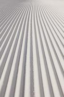 Texture of new groomed snow on empty ski slope photo