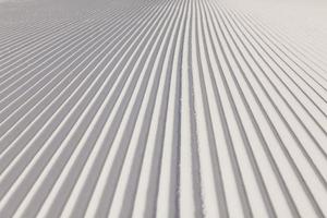 Textura de nieve recién preparada en pista de esquí vacía foto