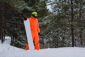 Snowboarder posing in winter forest photo
