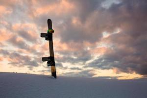 Powder texture and snowboard at sunset photo