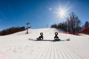 Bottom view on empty ski slope and equipment for snowboarding photo