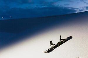 Powder texture and Equipment for snowboarding at sunset photo