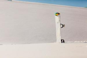 Snowboard and ski googles laying on a snow near the freeride slope photo