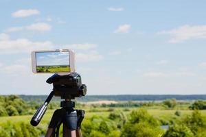 Smartphone on tripod capturing summer landscape photo
