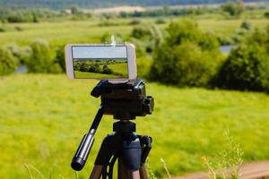 Smartphone on tripod capturing summer landscape photo