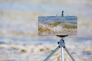 teléfono inteligente haciendo fotos y videos cerca del borde del mar