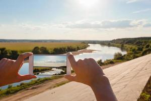 Someone using smartphone to taking photo of summer landscape