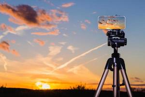 Smartphone on tripod capturing image of stunning sundown photo