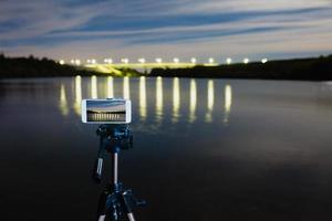 usando un teléfono inteligente como una cámara profesional en un trípode para capturar paisajes nocturnos foto