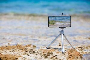 teléfono inteligente haciendo fotos y videos cerca del borde del mar