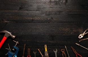 herramientas de trabajo antiguas sobre un fondo de madera negro oscuro.