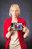 Blonde woman holding color board photo