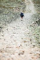 Mujer caminando por un sendero rocoso foto