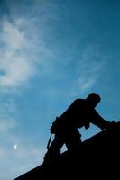 Contractor in Silhouette working on a Roof Top photo