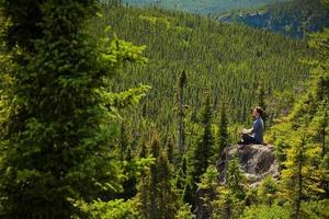 Young man on a rock in the middle of the nature photo