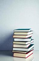 Stack of books on white reflective surface photo