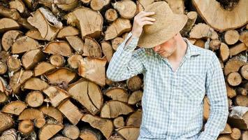 Woodcutter with straw hat on a background of wood photo