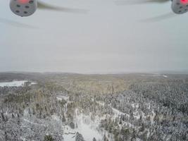 vista en quadcopter del bosque y la pequeña choza de madera canadiense durante el invierno. foto