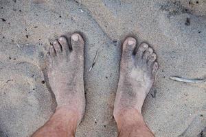 Men's feet in the sand photo