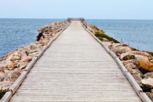 Muelle de madera largo con observatorio y vista al mar foto