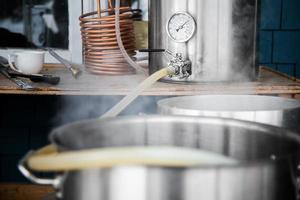 Home Brewing Kit and Pouring Craft Beer Wort into the Boil Kettle. photo