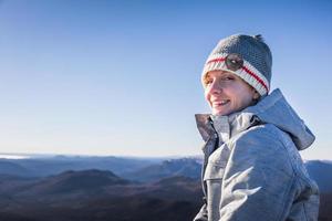 Mujer feliz disfrutando de la vista de la cumbre de la montaña Richardson