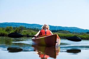 mujer descansando en un kayak y disfrutando de su vida