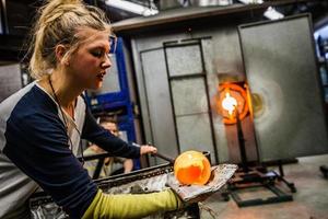 Two Women Shaping Blown Glass on the Blowpipe photo