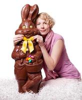 Blond Girl Adjusting Bowtie of a Chocolate Easter Bunny photo