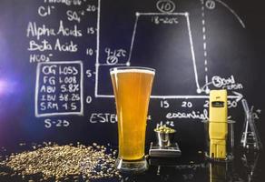 ciencia de la cerveza. pizarra con gráfico, datos y especificaciones, lúpulos, granos y herramientas sobre el proceso de producción foto