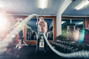 hombre trabajando con cuerdas de batalla foto