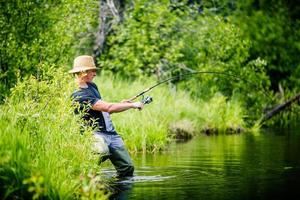 Young Fisherman Catching a big Fish photo