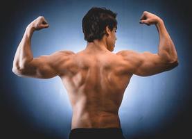 Culturista musculoso mostrando espalda y hombros. foto
