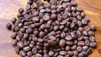 Light roasted coffee beans falling on the wooden background video