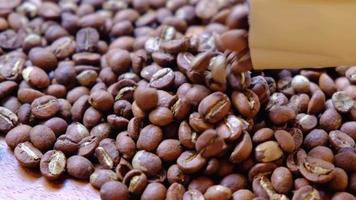 Light roasted coffee beans falling on the wooden background video