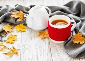 Cup of tea and autumn leaves photo