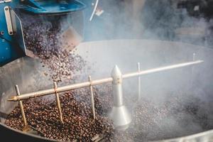 Roasted coffee beans steaming in cooling cylinder photo