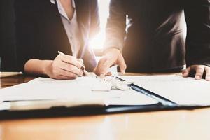 El agente inmobiliario da un acuerdo de pluma y documentos con el cliente para firmar el contrato. acuerdo de concepto.